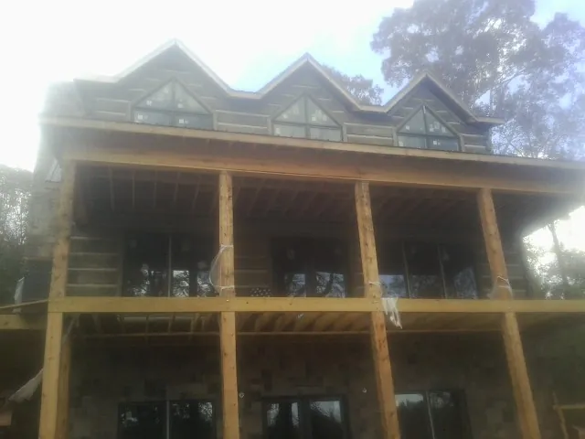 Dormers and porch framing on a large log home under construction — Roof Coating work by our crew in Paducah