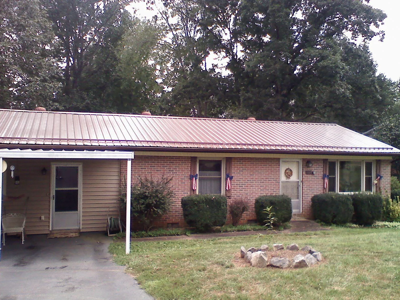 Bronze metal roof and carport on a brick ranch home — Roof Repair work by our crew in Paducah