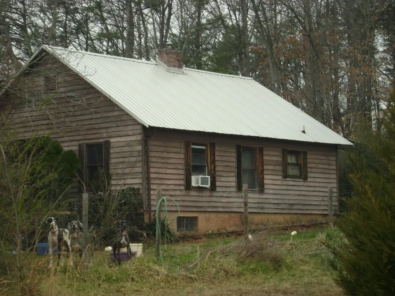 White metal roof on an old wood sided farmhouse, from a Metal Roof Installation job in Paducah